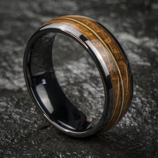 Black ceramic ring with whiskey barrel wood and guitar string inlay