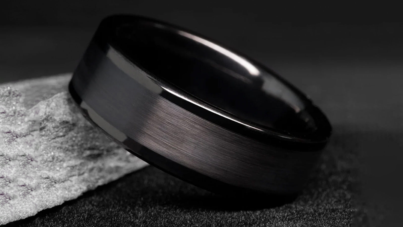 Minimalist black brushed tungsten ring for men representing strength and confidence.
