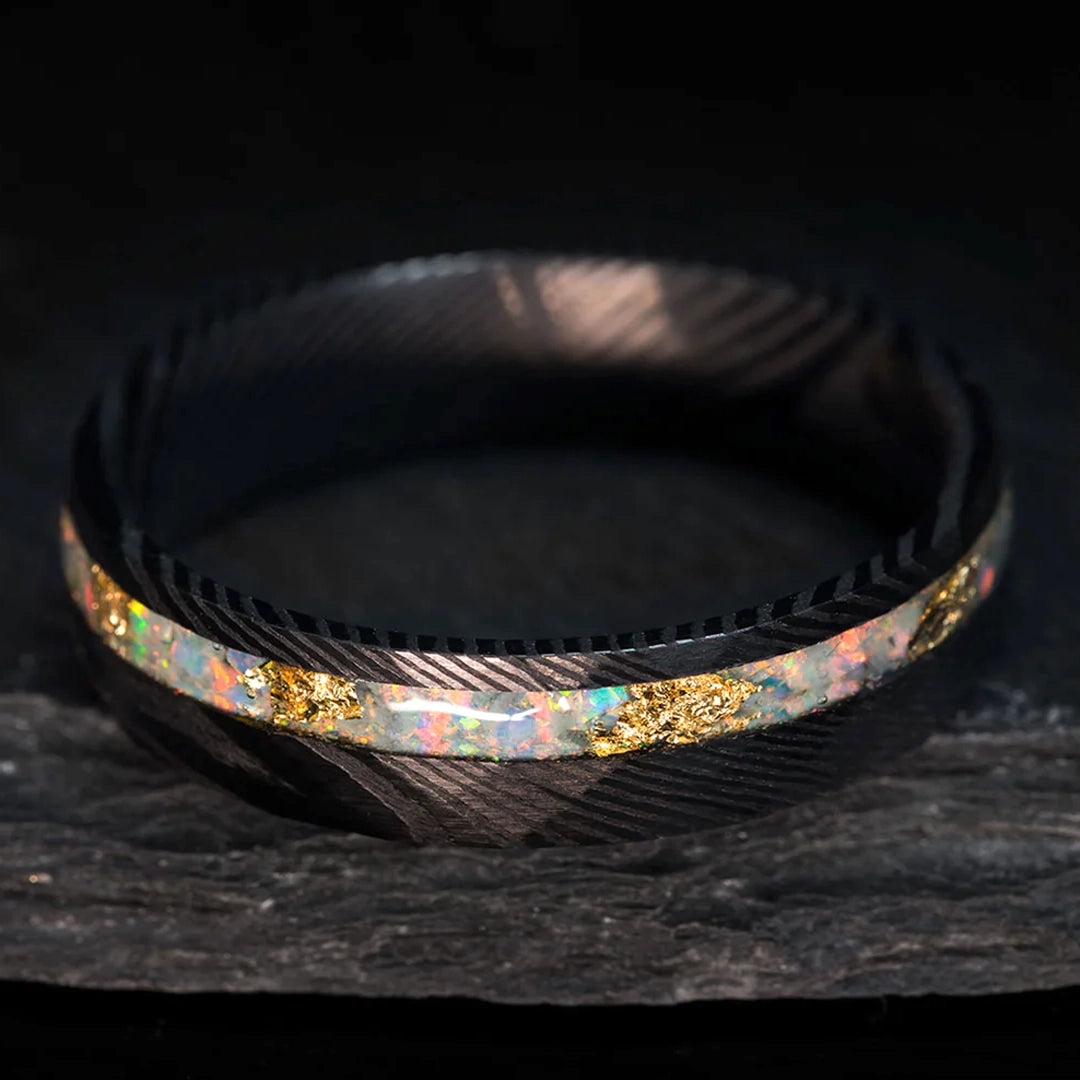 Damascus steel wedding ring with white opal and gold leaf inlay