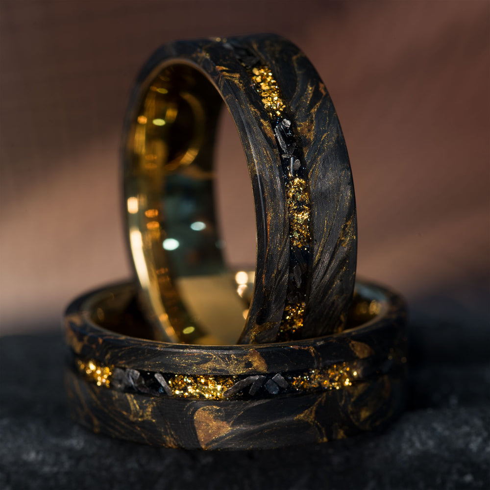 Black forged carbon fiber rings with gold foil & meteorite inlay. Gold tungsten interior. Unique swirls.