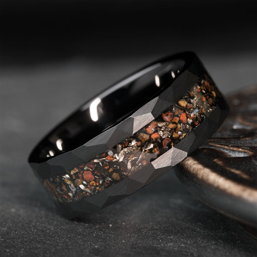 Black hammered tungsten ring with unique T-Rex bone and meteorite inlay. Features faceted edges for a striking look.