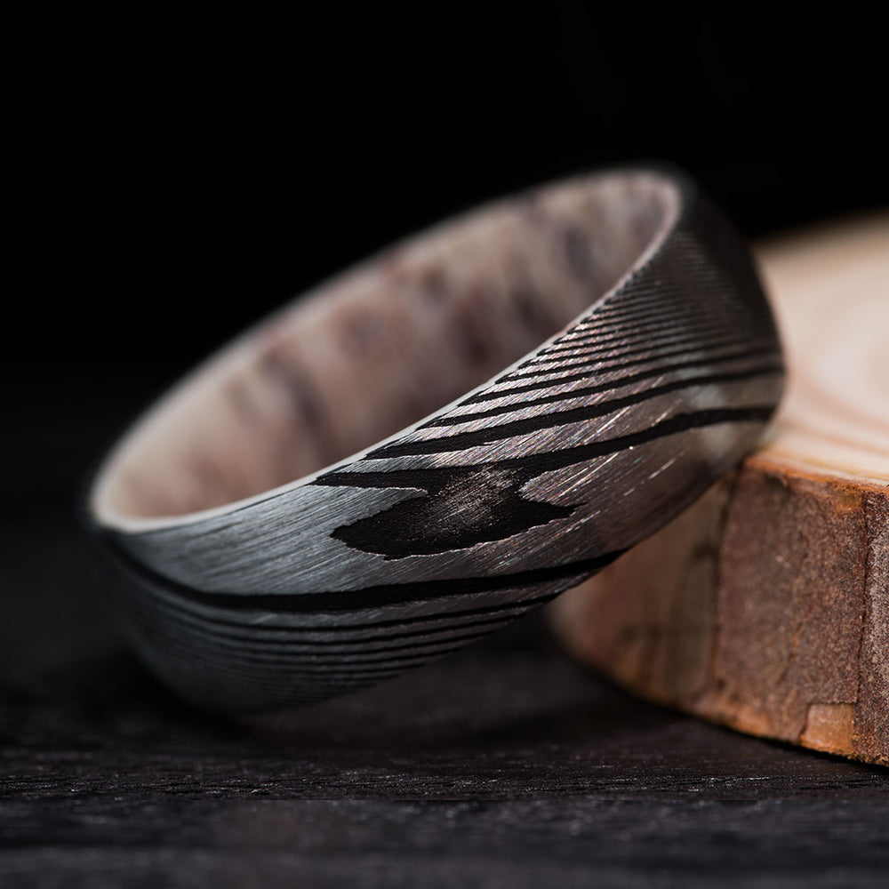 Paladin ring: twisted Damascus steel exterior, unique antler interior. Men's silver wedding band.