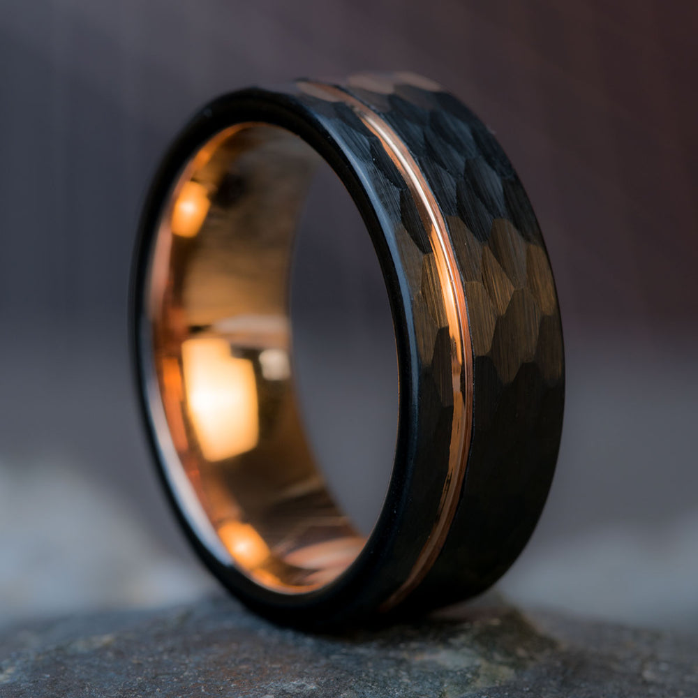 Black hammered tungsten wedding band with rose gold interior and offset inlay, 8mm wide, on product page.