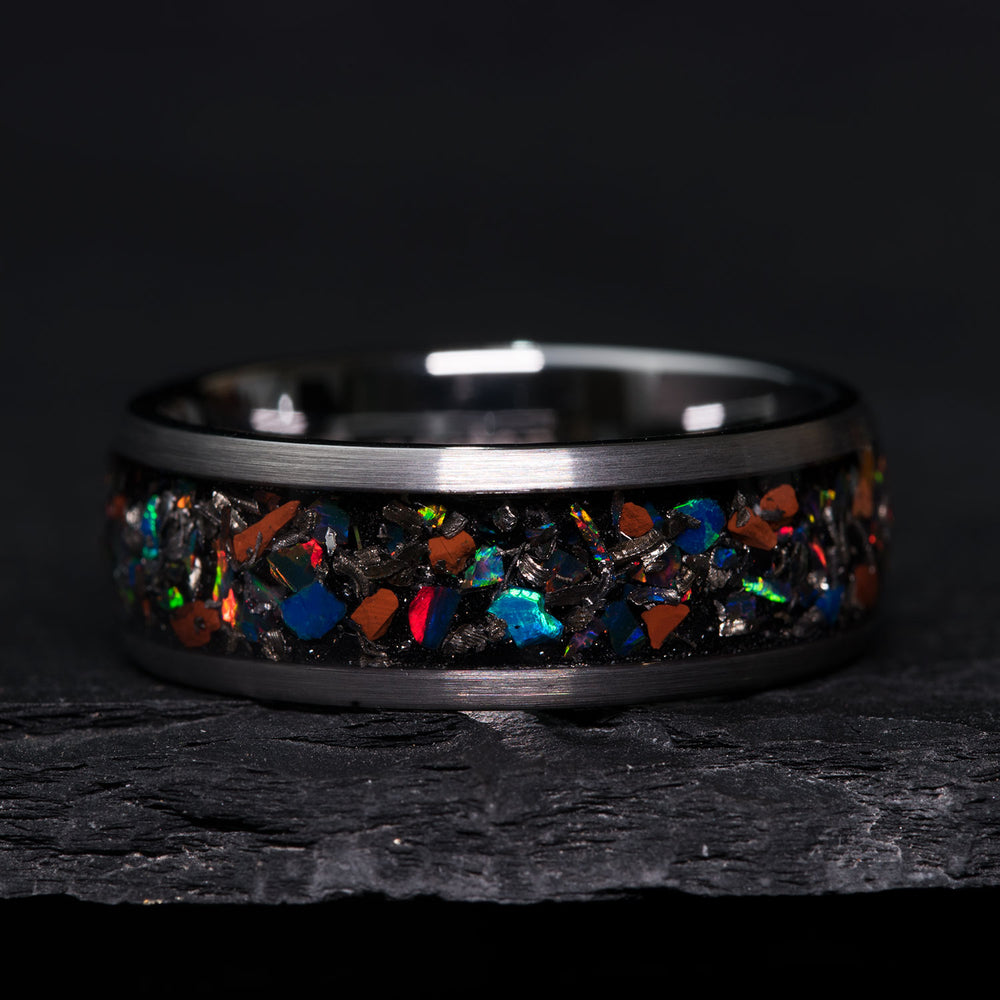 Tungsten carbide ring with opal, meteorite dust, and T. rex bone inlay.