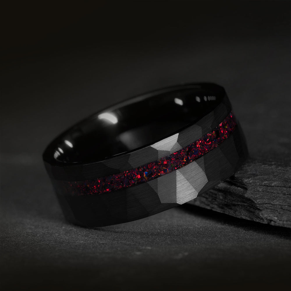 The Overlord hammered black tungsten wedding band with red starry sky opal inlay.