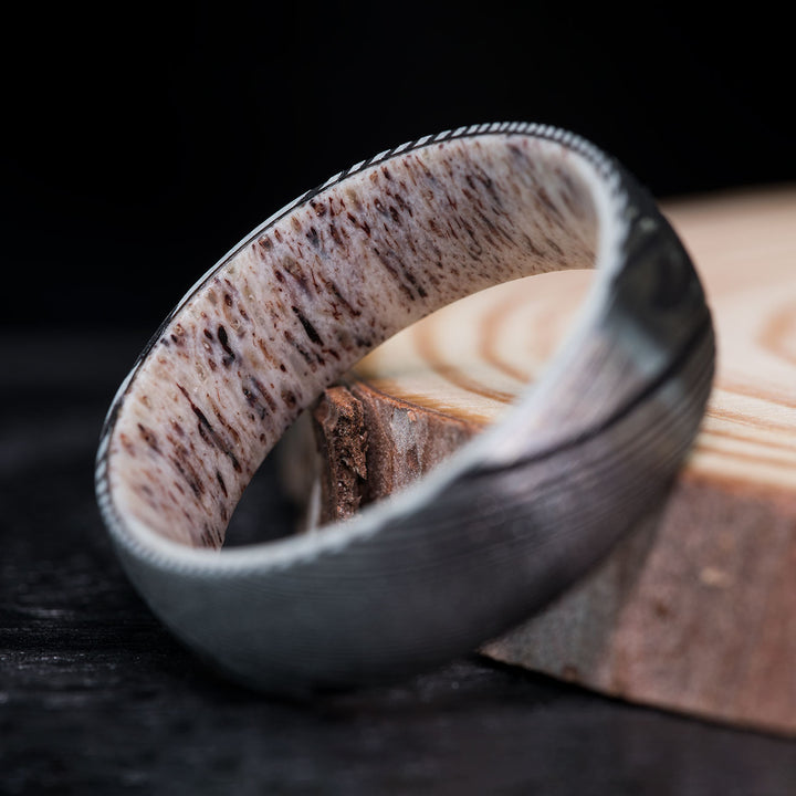 Close-up of a Damascus steel and antler ring, showing the details