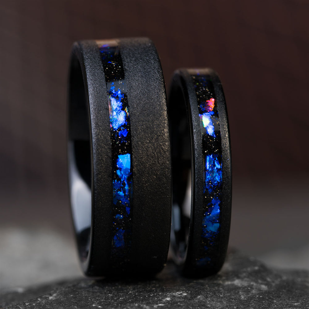 Black tungsten wedding bands with blue alexandrite and sandstone inlay, showcasing product appearance.