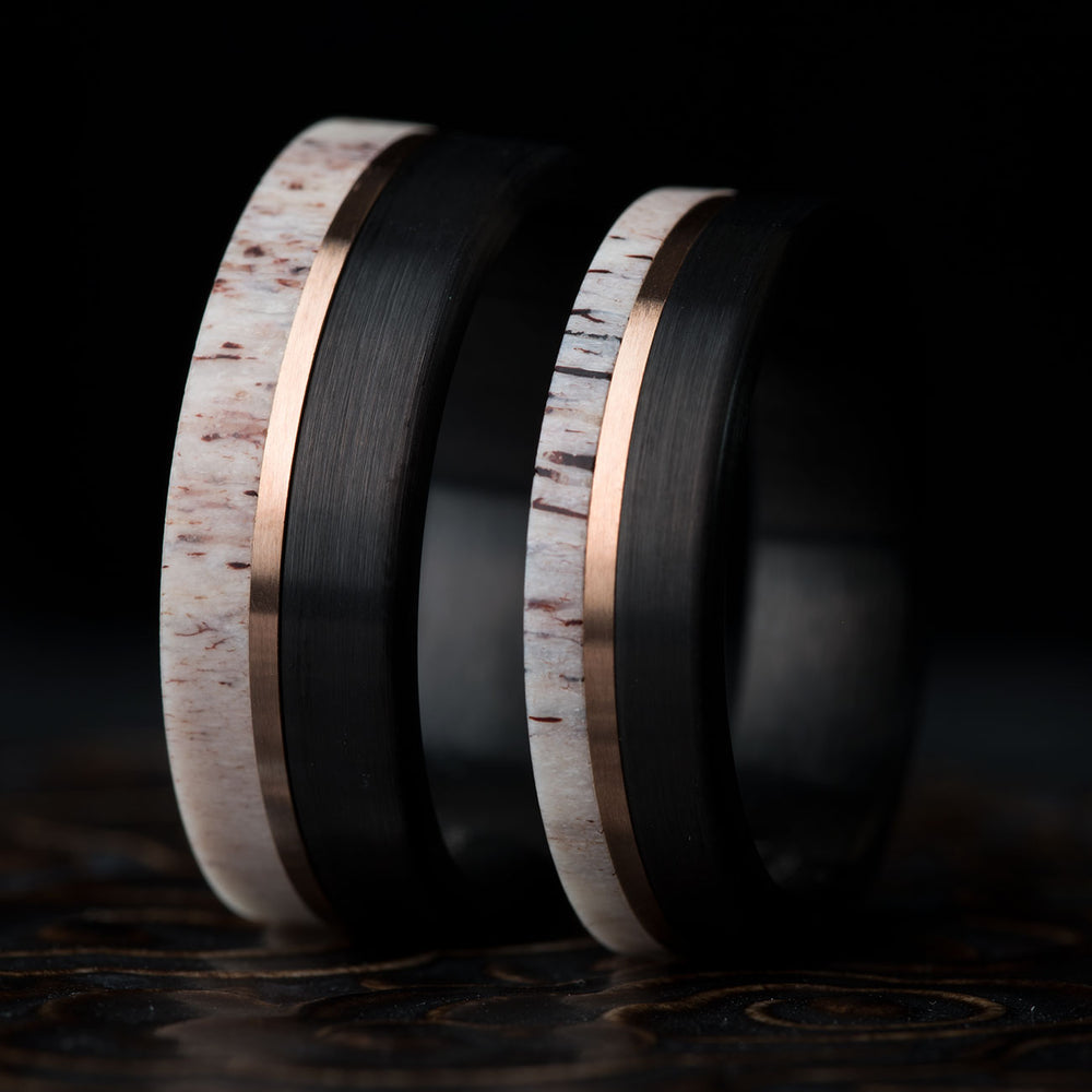 The Wild King men's wedding band: black tungsten, natural antler inlay, rose gold stripe. Product detail.